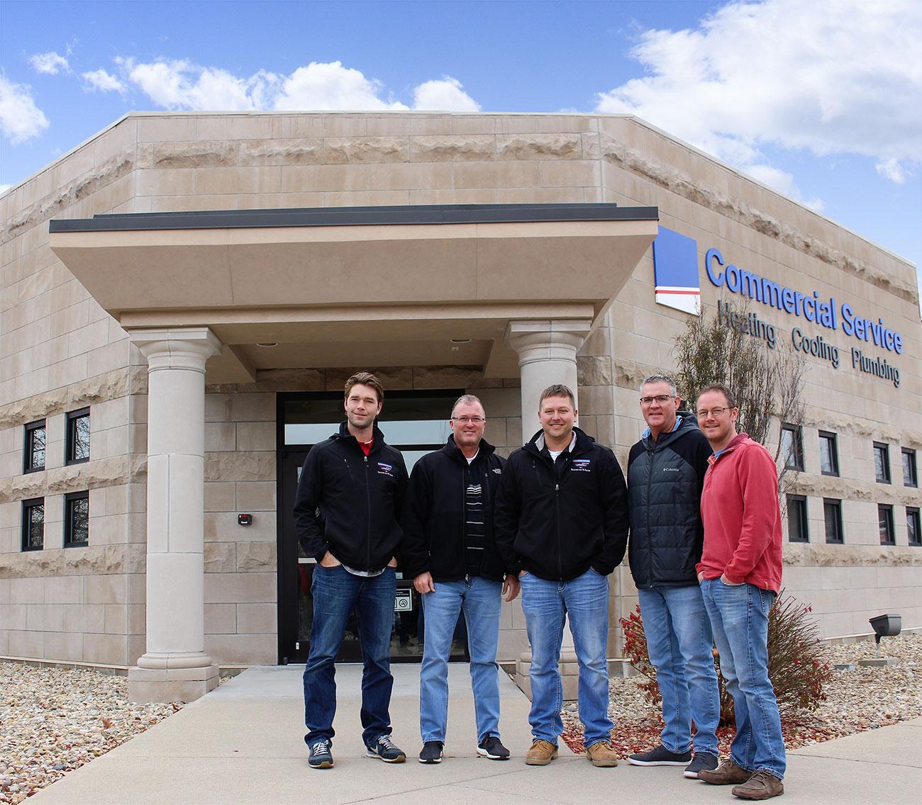 commercial service team standing in front of building