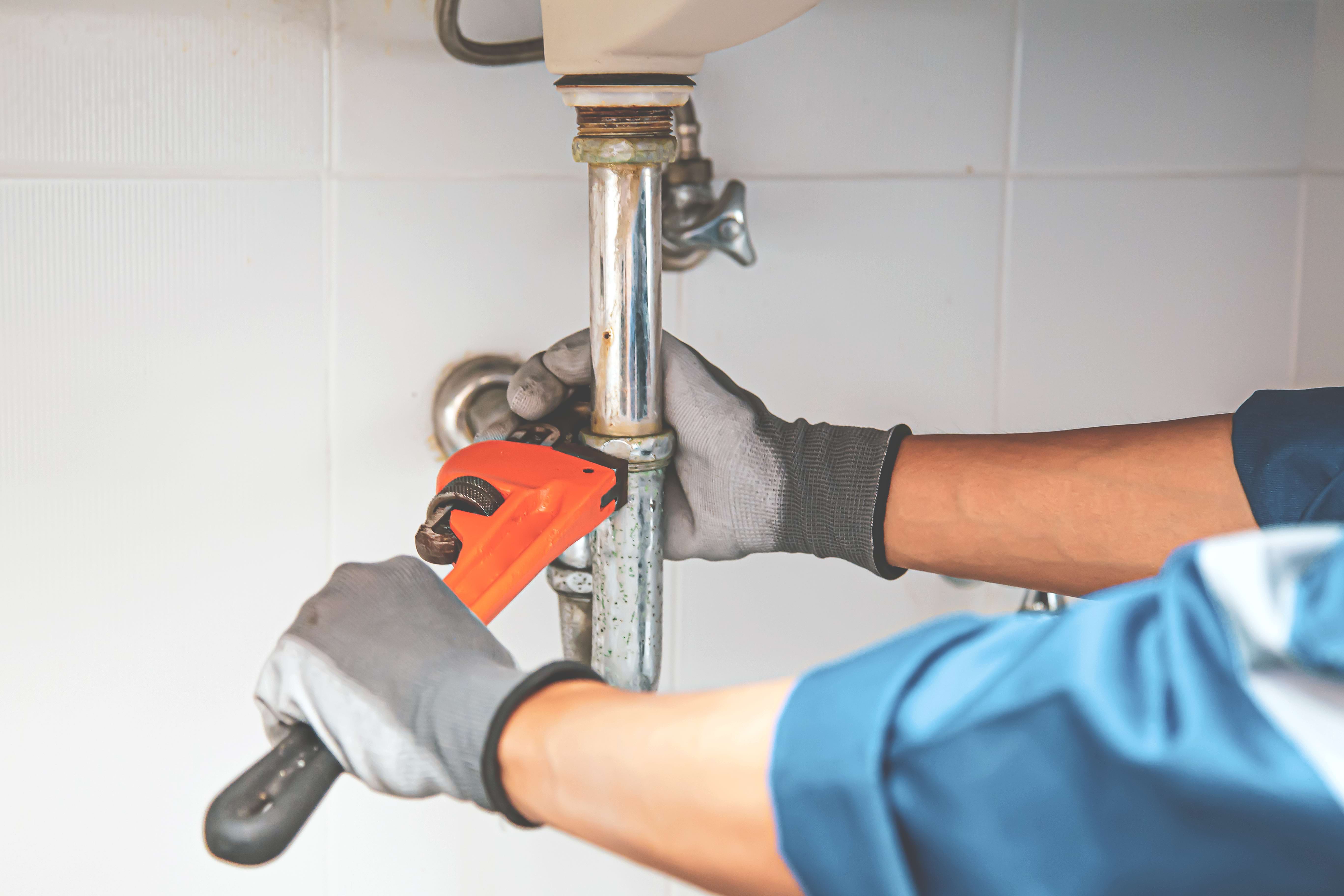 Plumber working on leaky faucet. 